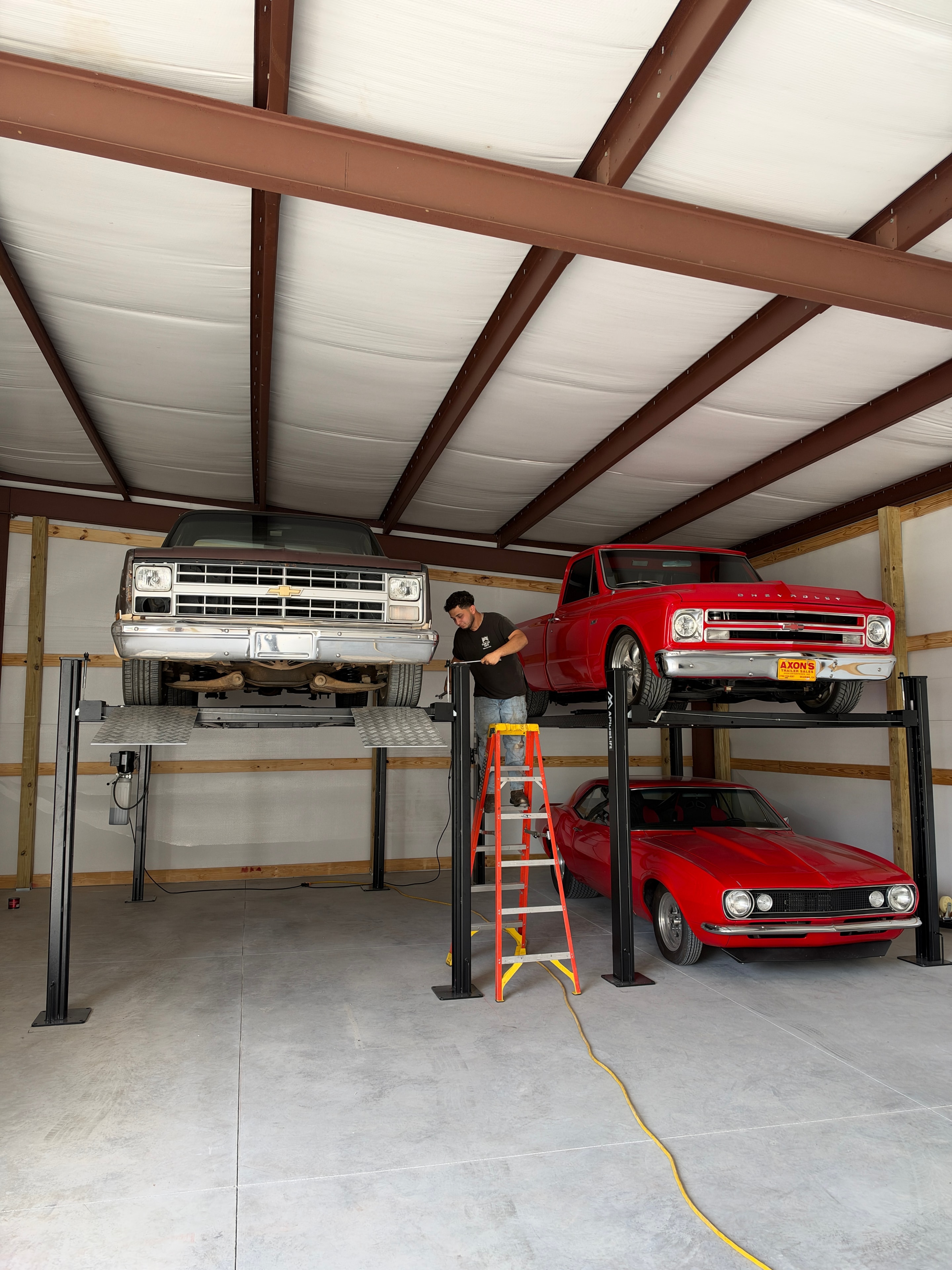 APlus 4-post lifts with classic Chevrolet trucks and Camaro during installation